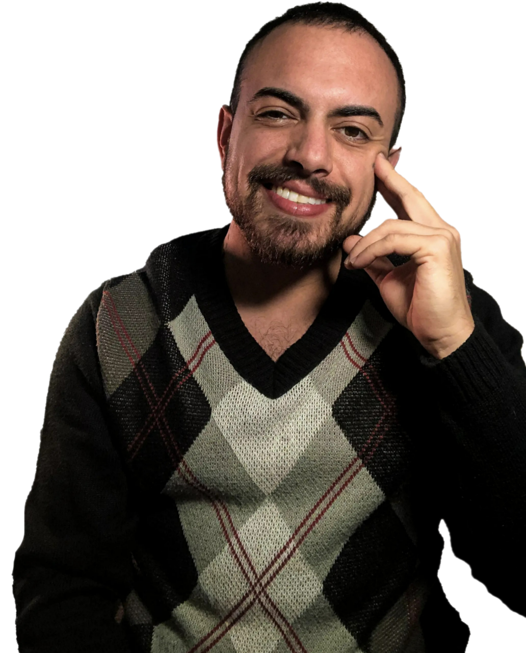 Foto de Pedro Acerbi utilizando um casaco xadrez marrom, cinza e verde e sorrindo com a mão apoiado no rosto